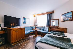 ヤコブスタードにあるピエタルサーレン カウプンギンホテッレのソファと薄型テレビが備わるホテルルームです。
