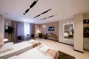 a hotel room with two beds and a mirror at Oasis Residence in Bishkek