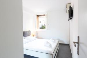 アンティーブにあるBNB RENTING Chez Dominique - 1 chbre 2-4pers Centre Antibes Migrainierのベッドと窓が備わる小さな白い客室です。