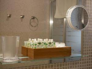 estante con artículos de aseo y espejo en el baño en CSE San Miguel, en Sevilla