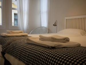 Una cama con dos toallas encima. en CSE San Miguel, en Sevilla
