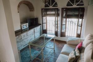 sala de estar con mesa de cristal y sofá en LA COVACHA DEL PINTOR, en Carmona