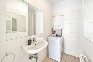 biała łazienka z umywalką i lustrem w obiekcie Vienna City Apartments Krongasse w Wiedniu +37 zdjęć