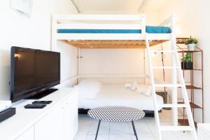 アンティーブにあるBNB RENTING Chez Dominique - Studio 2-4pers centre Antibes Fourmilliere 1erの二段ベッド、デスク、テレビが備わる客室です。