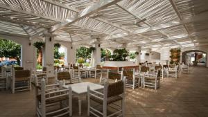 a patio with white tables and chairs in a building at Villetta Residence Chiusurelle in Porto Cesareo