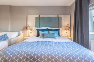 a bedroom with a large bed with blue pillows at Palm Court Hotel in Aberdeen