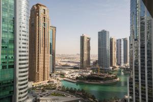 a view of a city with tall buildings and a river at HiGuests - Cozy Studio With Panoramic Views on the Lake in Dubai