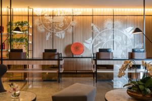 ジャカルタにあるSwissôtel Jakarta PIK Avenueの時計付きの壁とテーブル2台のあるレストラン