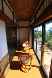 a room with a table and a chair on a balcony at Yadokari Kumano in Kumano