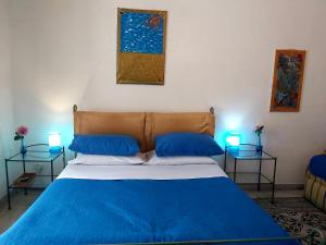 a bedroom with a blue bed with two tables at B&B Platamon in Naples