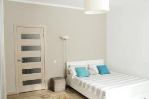 Dormitorio blanco con cama con almohadas azules en Flat in cottage close to the centre parking, WiFi, BBQ, en Leópolis