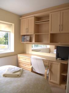 a bedroom with a bed and a desk with a computer at Station Approach in Solihull