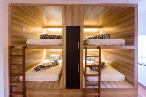 a room with four bunk beds and wooden walls at Back2Roots Backpackers in Windhoek
