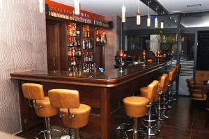 a bar with a row of brown bar stools at Hotel Filoxenia in Chania