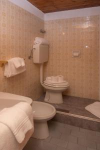 a bathroom with a toilet and a sink and a tub at Hotel Monte Triplex in Sauze dʼOulx