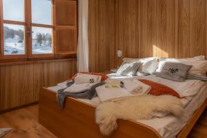 a bed with a pile of blankets and pillows on it at Hotel Monte Triplex in Sauze dʼOulx