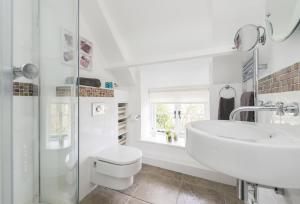 a white bathroom with a sink and a toilet at Vicarage Cottage in Powerstock +9 photos