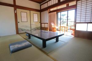 ein Zimmer mit einem Tisch in der Mitte eines Zimmers in der Unterkunft Yadokari Kumano in Kumano