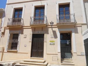 a building with balconies and a door and stairs at Hostal Casa Museo La Pájara in Hellín