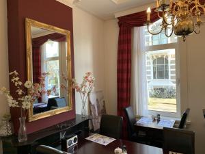 a dining room with a table and a mirror at Hotel Oorsprongpark City Centre Utrecht in Utrecht