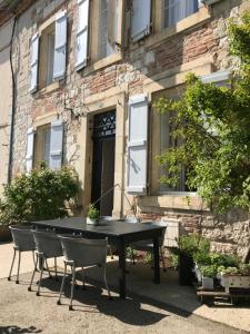 een zwarte tafel en stoelen voor een gebouw bij l'autre maison in Penne-dʼAgenais