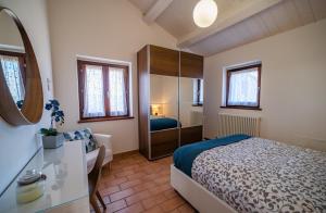 a bedroom with a bed and a desk and a mirror at Country House Ca' Brunello in Urbino