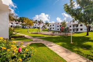 A garden outside Apartamentos Son Bou Gardens By MENORCARENTALS