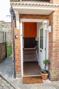 una entrada a una casa de ladrillo con una puerta blanca en Glastonbury Town Apartment, en Glastonbury