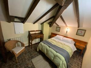 a bedroom with a bed and a desk and a chair at Viviendas Rurales la Fragua in Aliezo