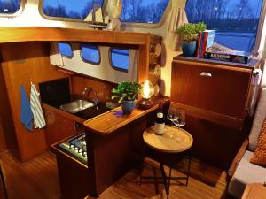 eine kleine Küche in einem Wohnwagen mit einem Tisch in der Unterkunft Motor Yacht Almaz in Amsterdam