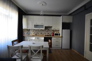 a kitchen with white cabinets and a table and chairs at Two Minutes To Galata Tower in Istanbul