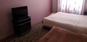 ニジネヴァルトフスクにあるApartment on Mira 94のベッド2台、薄型テレビが備わるホテルルームです。