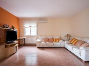a living room with a white couch and a television at Belvilla by OYO Casa Crepuscle in El Vendrell