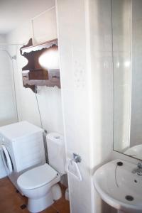a white bathroom with a toilet and a sink at Homenfun Menorca Cala en Porter in Cala en Porter