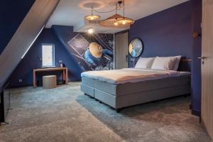 um quarto com uma cama com uma parede azul em Hotel Marktstad em Schagen