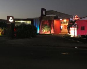 a night view of a building with neon lights at Lotu's Motel in Arapiraca