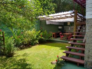 a garden with a wooden staircase and a table at Suites Helena in Ilhabela