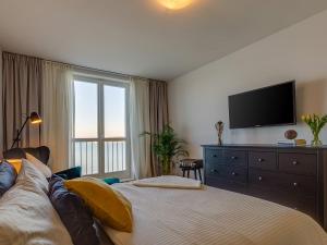 a bedroom with a bed with a television and a dresser at Bella Vista Premium Apartment in Poreč
