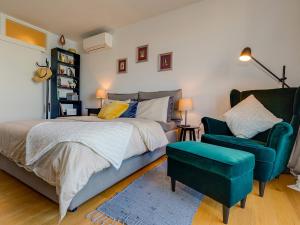 a bedroom with a bed and a blue chair at Bella Vista Premium Apartment in Poreč