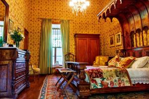 a bedroom with a large bed and a chandelier at Hotel Hacienda los Lingues in Los Lingues