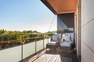 ein Balkon mit Stühlen und Blick auf das Meer in der Unterkunft HHBCN Beach Apartment Gava #2 in Gavà
