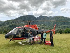 un grupo de personas de pie junto a un helicóptero en Barraco Lodge, en Las Gualas