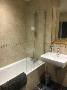 La salle de bains est pourvue d'une baignoire, d'un lavabo et d'une douche. dans l'établissement Toothbrush Apartments - Ipswich Waterfront - The Cambria, à Ipswich