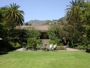 a group of chairs and a table in front of a house at Hotel Hacienda los Lingues in Los Lingues