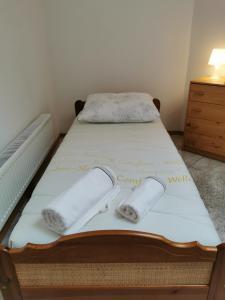 Una cama con dos toallas blancas encima. en WHITE Apartment, en Jabłonna