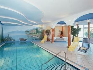 a swimming pool in a hotel with a painting on the wall at Hotel Deichgraf in Cuxhaven