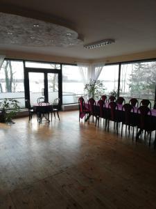 duży pokój z krzesłami, stołami i oknami w obiekcie Zajazd Rybaki w mieście Płock