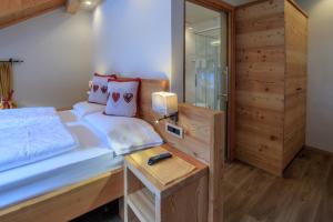 a bedroom with a bed and a dresser at Hotel Garni Snaltnerhof in Ortisei
