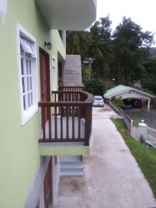 a balcony of a house with a car on the street at Rose Heights Apartments No 5 in Castries