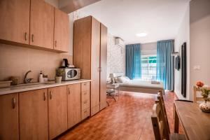 a kitchen with wooden cabinets and a living room at Avital Hotel in Jerusalem